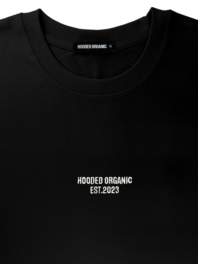 Nærbillede af Hooded Organic-logo trykt på sort T-shirt – 100% økologisk bomuld i høj kvalitet