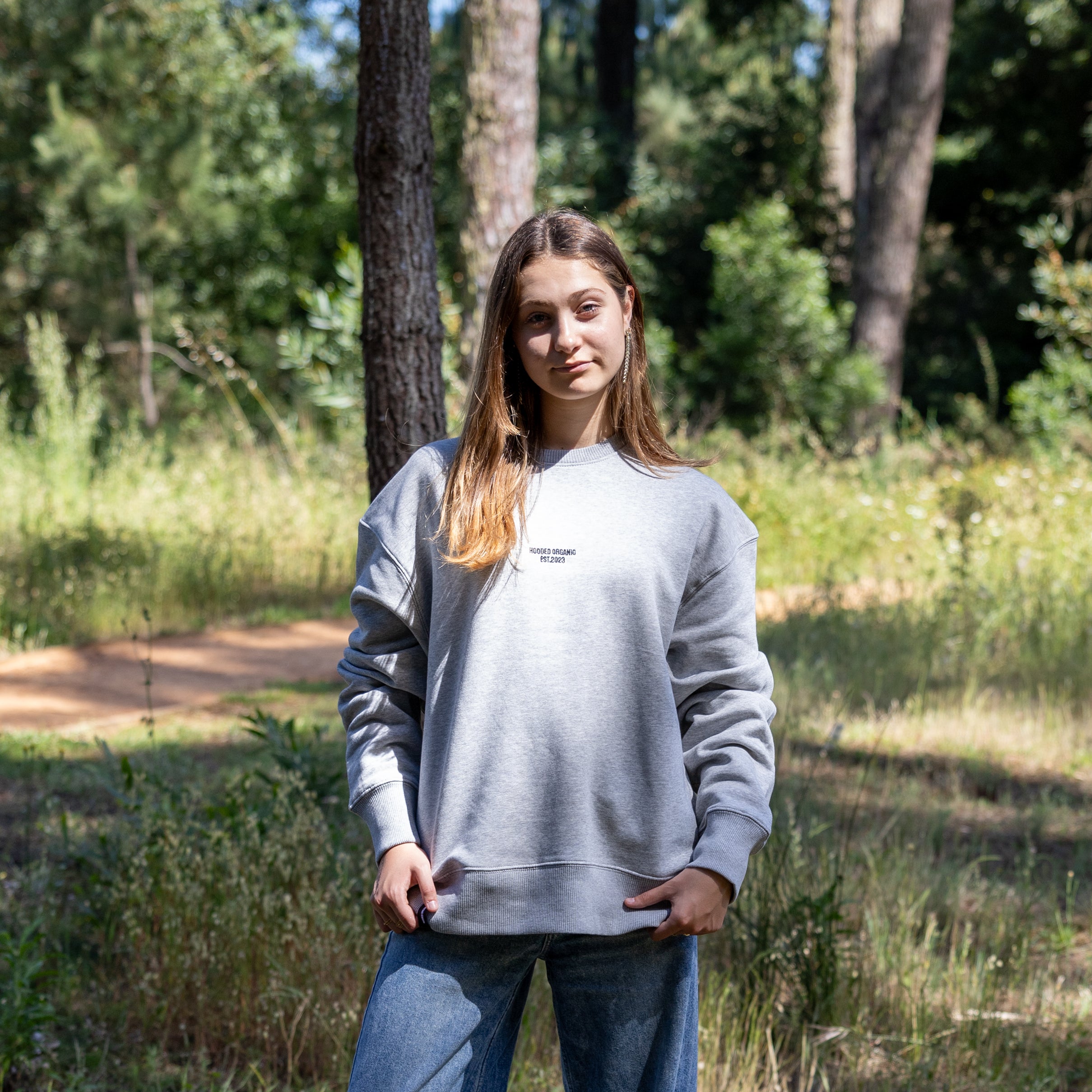 Kvindelig model iført tung grå sweatshirt i afslappet pasform – økologisk bomuld og dansk design i høj kvalitet