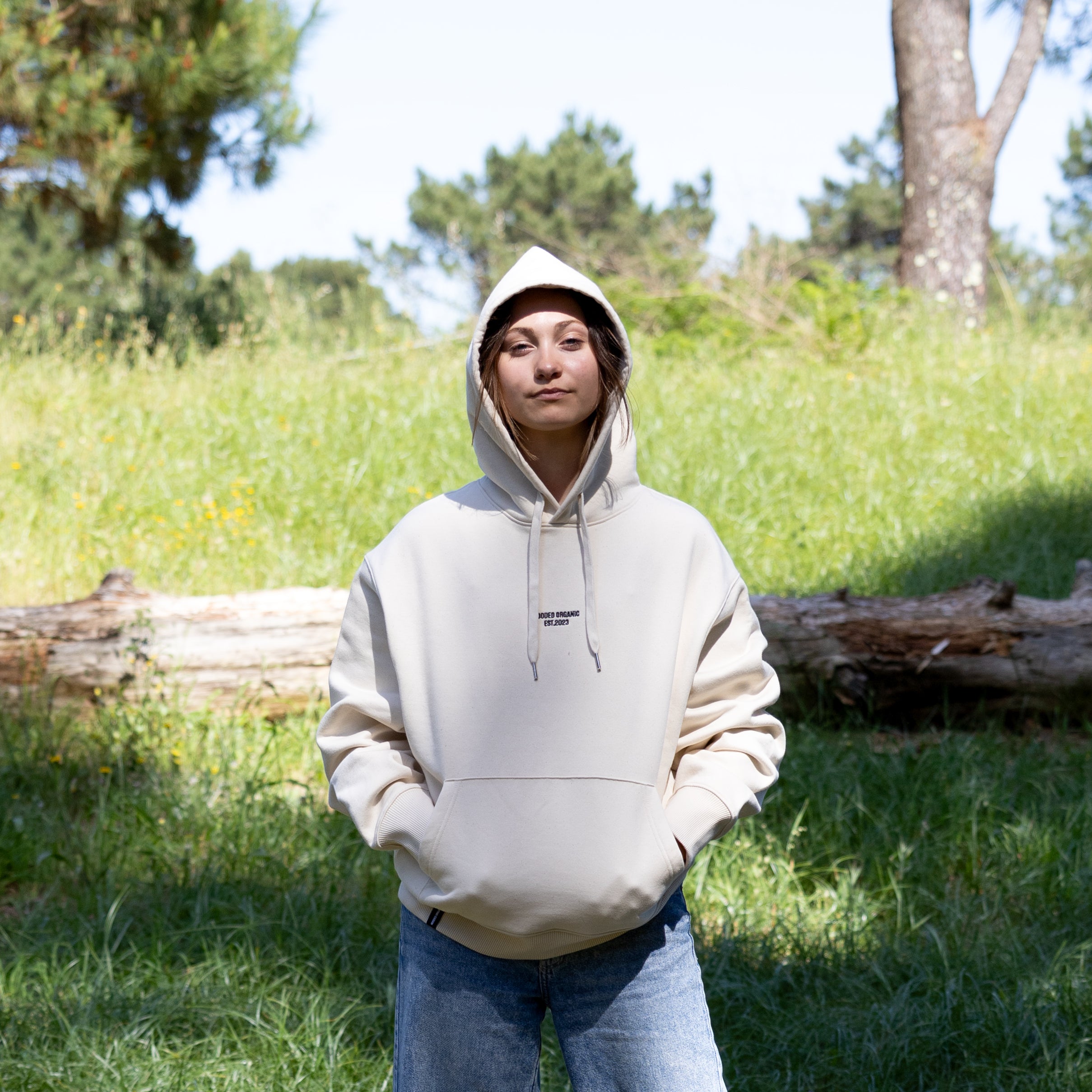 Kvindelig model forfra i beige hoodie med hætten oppe – dansk design og 100% økologisk tekstil
