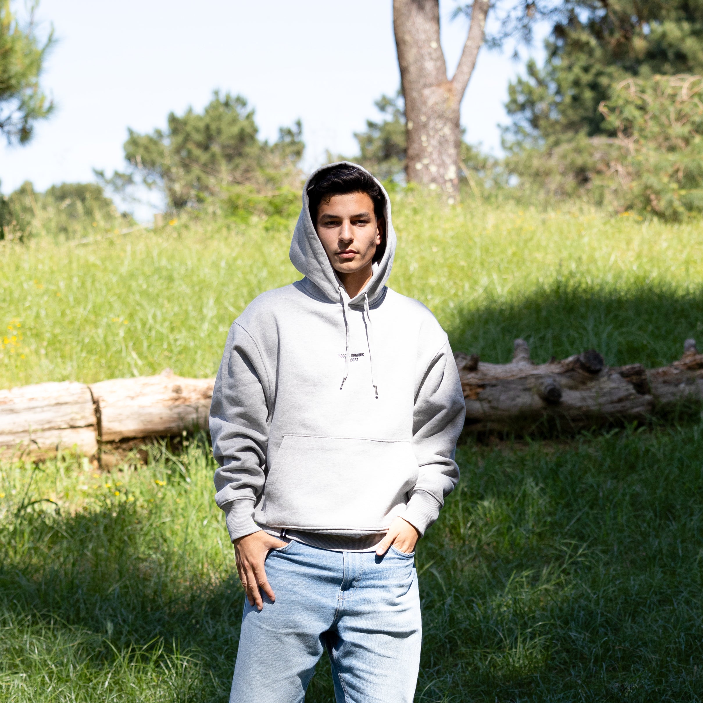 Grå hoodie med hætten oppe set forfra på mandelig model – 100% økologisk bomuld og dansk design
