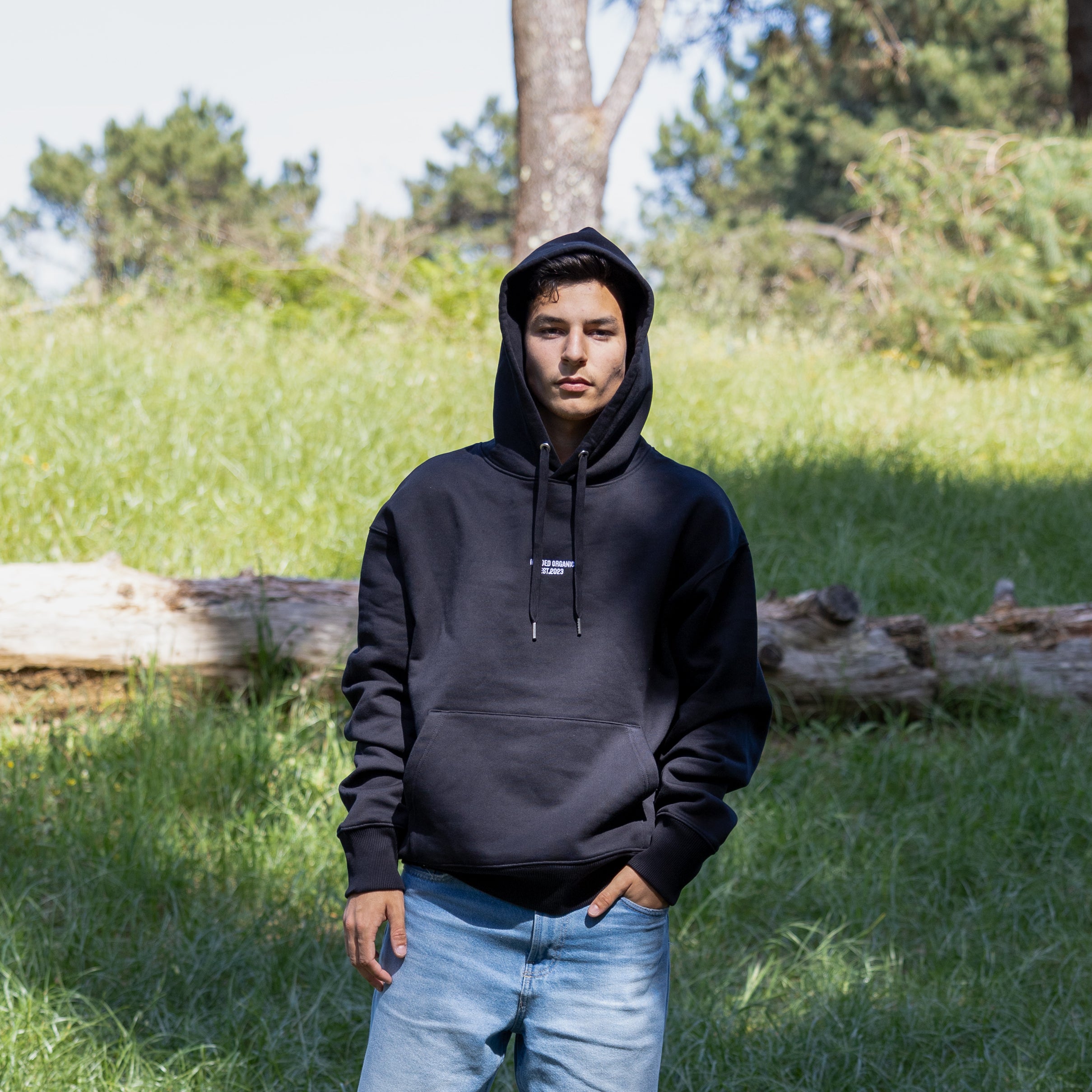 Sort hoodie med hætten oppe på mandelig model – 100% økologisk og afslappet pasform
