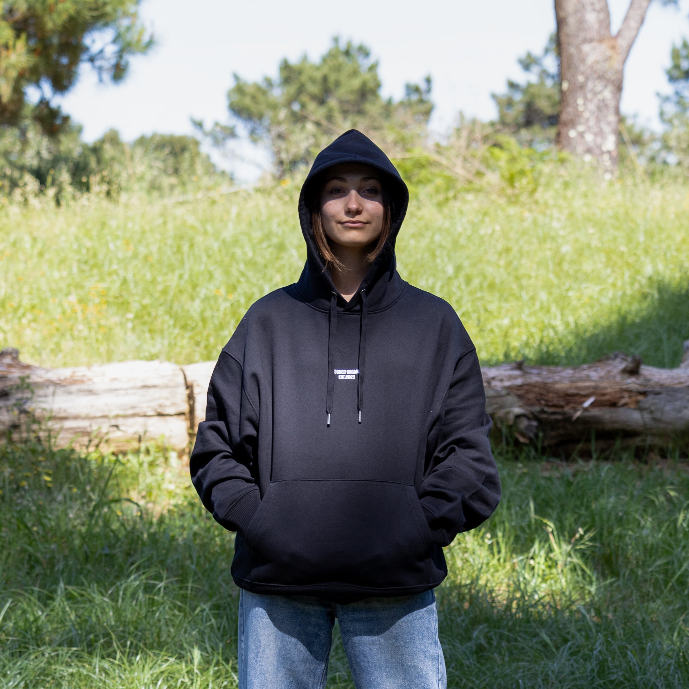 Sort hoodie med hætten oppe set forfra – 100% økologisk, komfortabel og med tydeligt Hooded Organic-logo