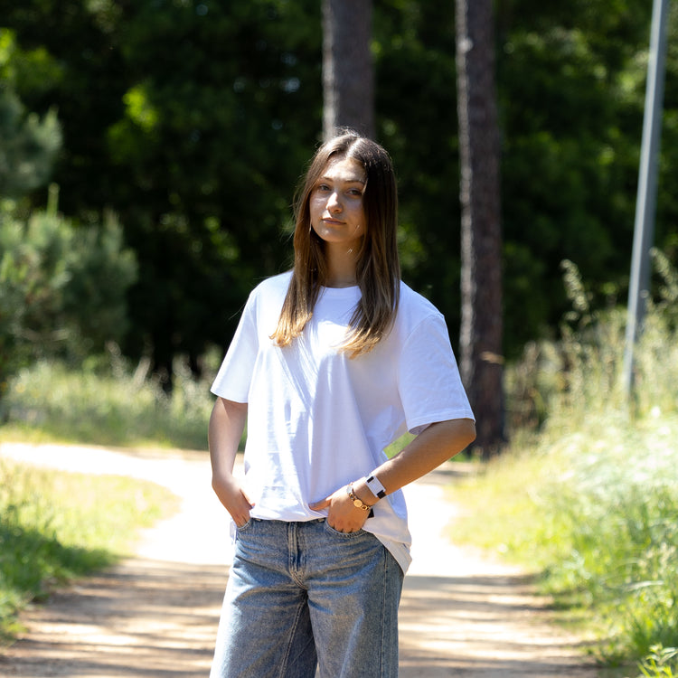 Hvid T-shirt vendt let sidelæns på kvindelig model – 100% økologisk og diskret cool
